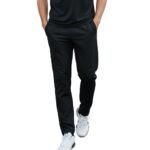 Man in black athletic t-shirt and track pants walking forward on white background — fitness apparel model