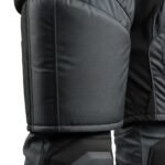 Close-up view of the padded thigh section on black tactical pants with detailed stitching.