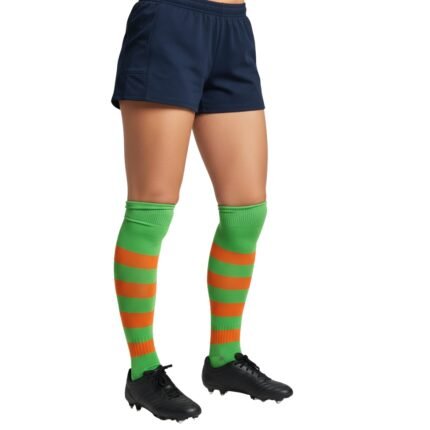 Pair of bright green rugby socks with alternating orange and green horizontal stripes and a ribbed green cuff at the top, worn with black cleats.