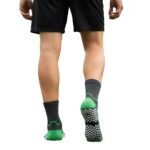 Back view of a model wearing soccer grip socks, showing the heel and calf area on a plain background.