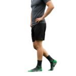Side view of a model wearing soccer grip socks, showing the fit around the ankle and foot on a plain background