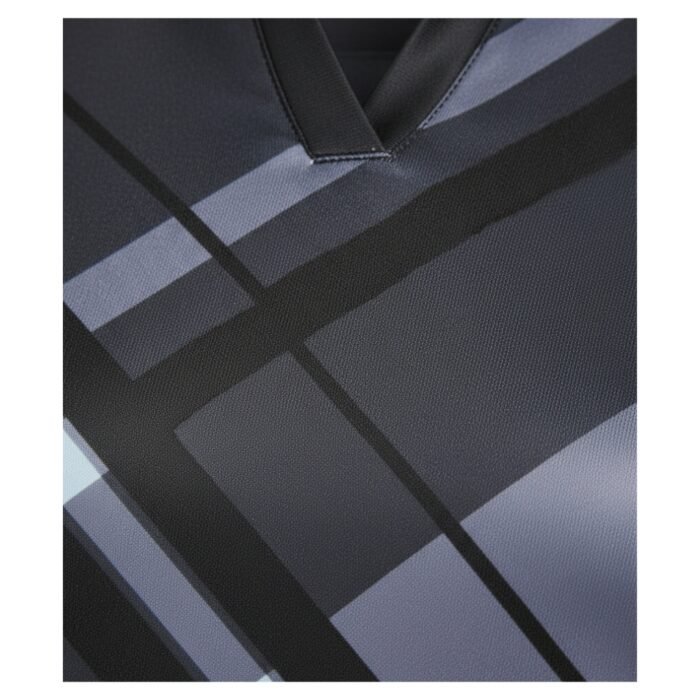 Close-up of a V-neck shirt with a gray and black grid-like geometric pattern on the fabric.