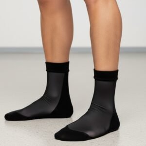 Close-up of a person’s legs wearing black socks with a sleek, smooth finish.
