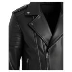 Close-up of a black leather jacket showcasing the asymmetrical zipper design, quilted shoulder detailing, and silver stud accents on the lapel.