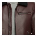 Close-up view of the upper section of a burgundy leather jacket with a textured finish, featuring a black shearling-style collar, metal zippered chest pocket, and part of a front zipper
