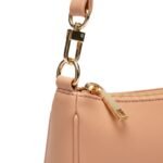 Close-up view of a leather shoulder bag featuring smooth apricot leather, a gold-tone zipper, and a polished strap buckle.
