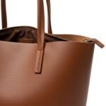 Tan leather tote bag with front buckle detail and two leather handles
