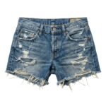 Front view of low rise denim shorts with button fly and distressed fabric.