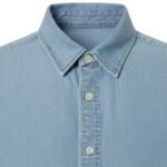 Men’s light blue denim button-down shirt close-up of the point collar and front button placket with two buttons visible.