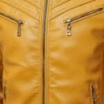 Mustard yellow men’s leather jacket material close-up view with visible texture and zipper details.