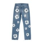 Back view of faded blue denim jeans with scattered white floral patterns on the legs and back pockets.