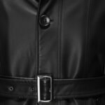 Black leather long coat close-up showing the button detail and belted waist buckle.