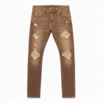 Tan brown ripped jeans on white background with large rips on thighs and smaller rips near pockets.
