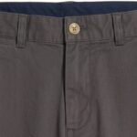 Close-up view of men’s chino pants waistband and pocket area, showing fabric texture and stitching on a neutral background.