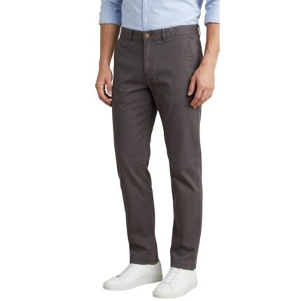 Man wearing chino pants and a casual top, standing front facing against a white background.