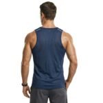 Back view of a man wearing a gym tank top and shorts, standing in a studio with a plain background.