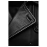 Close-up view of a black leather collar with detailed stitching and a buttonhole, showcasing premium craftsmanship and texture.