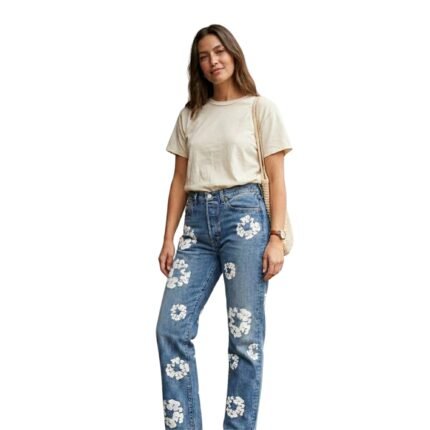 Woman wearing light blue floral jeans with beige top and straw bag, full-body outfit shot.