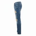 Side view of ripped blue jeans on white background showing front and back pockets.