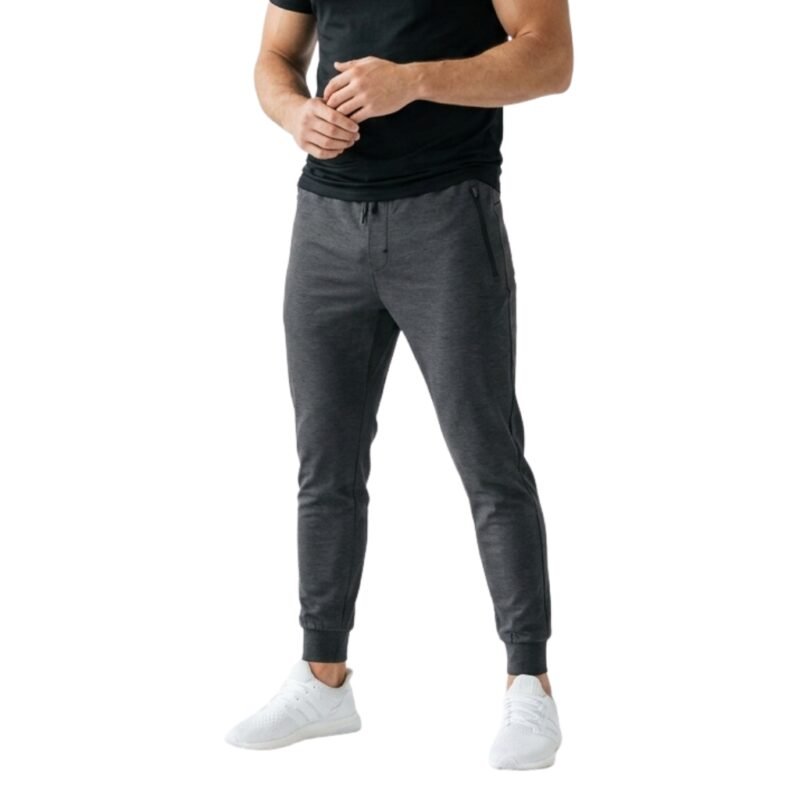 Man wearing tapered joggers and sneakers, standing front facing against a white background.