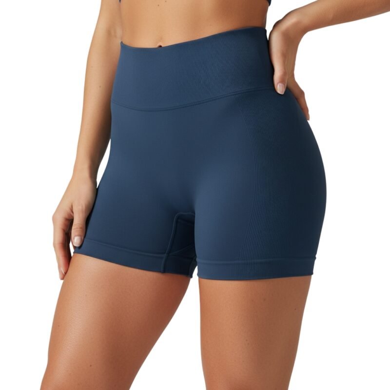 Front view of a woman wearing high-waisted black yoga shorts and sports bra, standing in a relaxed pose