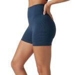 Side view of a woman wearing high-waisted black yoga shorts and sports bra, showing fit and length.