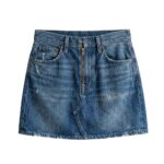 Studio shot of custom medium-wash denim mini skirt with front zipper and distressed vintage aesthetic, manufactured by Eco Jersey Limited