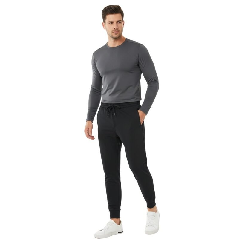 Male model wearing men’s rugby joggers and a matching rugby top, standing relaxed to show the elastic waistband, tapered legs, and cuffed ankles on a plain background.