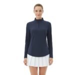 Model wearing a women’s quarter‑zip long sleeve golf dress, shown standing in a relaxed pose to highlight the tailored fit, long sleeves, and above‑the‑knee athletic silhouette.