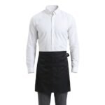 Front view of a white shirt and black waist apron server uniform laid out on a flat surface.