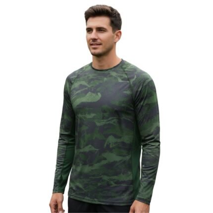 Model wearing a soccer long sleeve performance shirt, standing to show the close base-layer fit, crew neckline, fitted long sleeves, and bold chest logo icon.