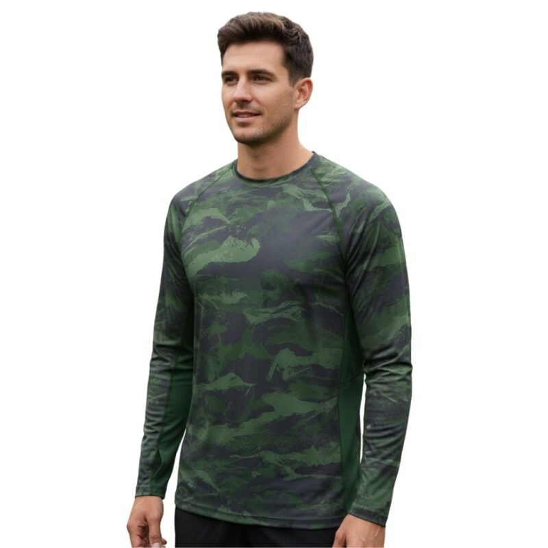 Model wearing a soccer long sleeve performance shirt, standing to show the close base-layer fit, crew neckline, fitted long sleeves, and bold chest logo icon.