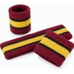 Stack of terry cloth tennis sweatbands arranged together, including multiple headbands and wristbands for athletic use.