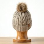 Back view of a winter beanie hat displayed on a plain background.