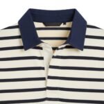 Close-up front view of women’s striped rugby short sleeve polo shirt showing the buttoned collar, chest placket, and small front logo icon on the striped fabric.