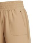 Close-up of women’s high-waisted tennis shorts pocket, showing hand-in-pocket detail, curved hem, and smooth performance fabric.