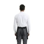 Back view of a unisex server uniform with white shirt and black waist apron tied at the back.