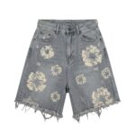 Black and gray distressed denim shorts with heavy ripped detailing and frayed hem.