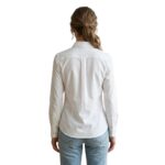 Female model wearing custom white button-down blouse back view – custom women’s corporate workwear shirt