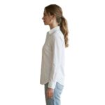 Female model wearing custom white button-down blouse side view – custom women’s corporate workwear shirt