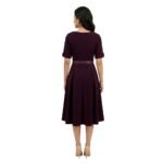 Female model wearing a casual dress, back view on a plain background.