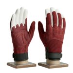 Pair of dirt bike gloves in deep brick red and white color on a plain background.