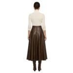 Back view of model wearing brown leather pleated mini skirt