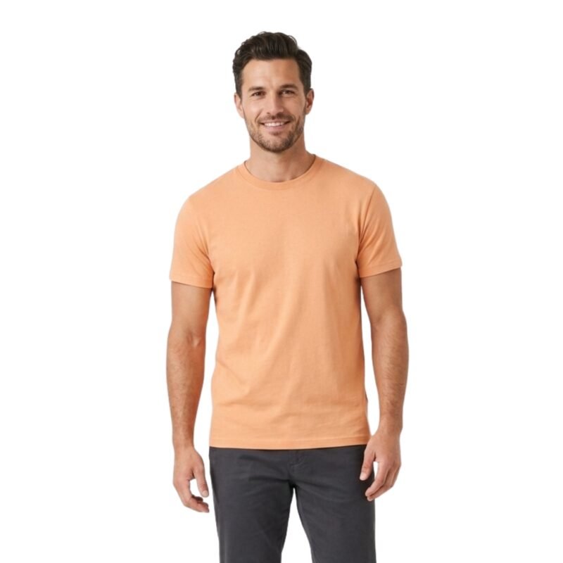 Male model wearing a peach crew neck t‑shirt, standing against a plain background.