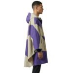 Male model wearing a waterproof rain poncho side view, showing hood, drape, and mid‑length coverage.
