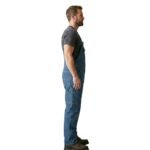 Side view of men’s overalls on plain background.