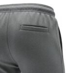 Close-up view of the back pocket on soccer sweat pants, showing the smooth knit fabric, clean stitching, and subtle logo icon detail.