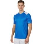 Model wearing a soccer team jersey, standing to show the athletic fit, crew neckline, short sleeves, and bold chest logo icon on smooth quick‑dry fabric.