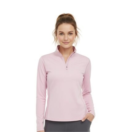 Woman wearing a pink lightweight golf quarter‑zip top on the course, with a stand collar, half zipper, long sleeves, and a small logo icon on the left chest.