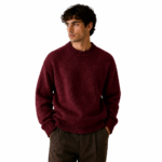 Front view of a male model wearing a maroon chunky crew-neck knit pullover sweater on a white background showing the colour option for the brown knitted sweater product